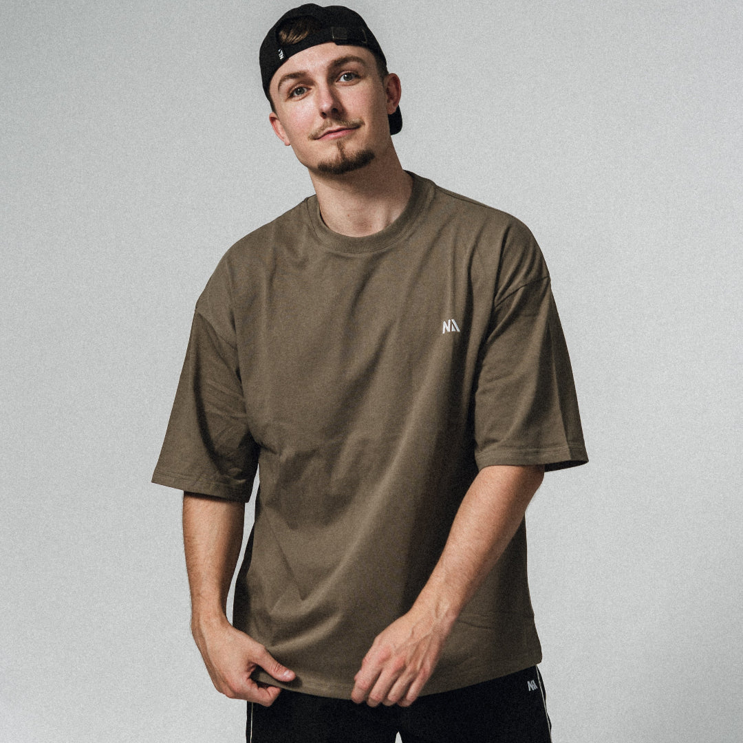 NA's Oversized t-shirt er beskrevet som det perfekte pump cover, gennemført pasform og maksimal komfort. Det bløde og åndbare bomuld kombineret med det ikoniske oversized box fit - gør den ideel som både træningstrøje og casual hverdagslook. Med drop shoulders og et naturligt fald over brystet, der skaber en flatterende silhuet, går du aldrig galt i byen med den her t-shirt.