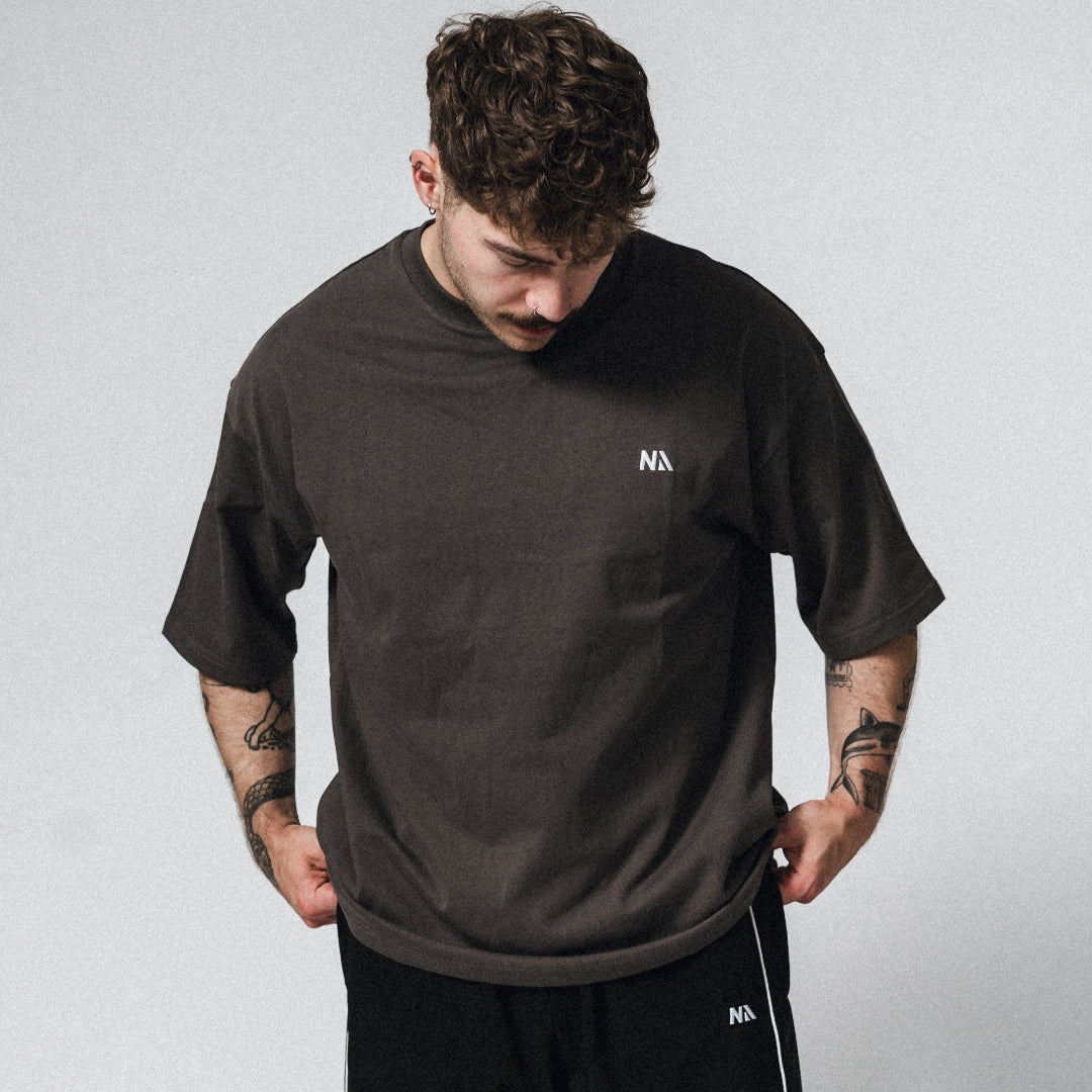 NA's Oversized t-shirt er beskrevet som det perfekte pump cover, gennemført pasform og maksimal komfort. Det bløde og åndbare bomuld kombineret med det ikoniske oversized box fit - gør den ideel som både træningstrøje og casual hverdagslook. Med drop shoulders og et naturligt fald over brystet, der skaber en flatterende silhuet, går du aldrig galt i byen med den her t-shirt.