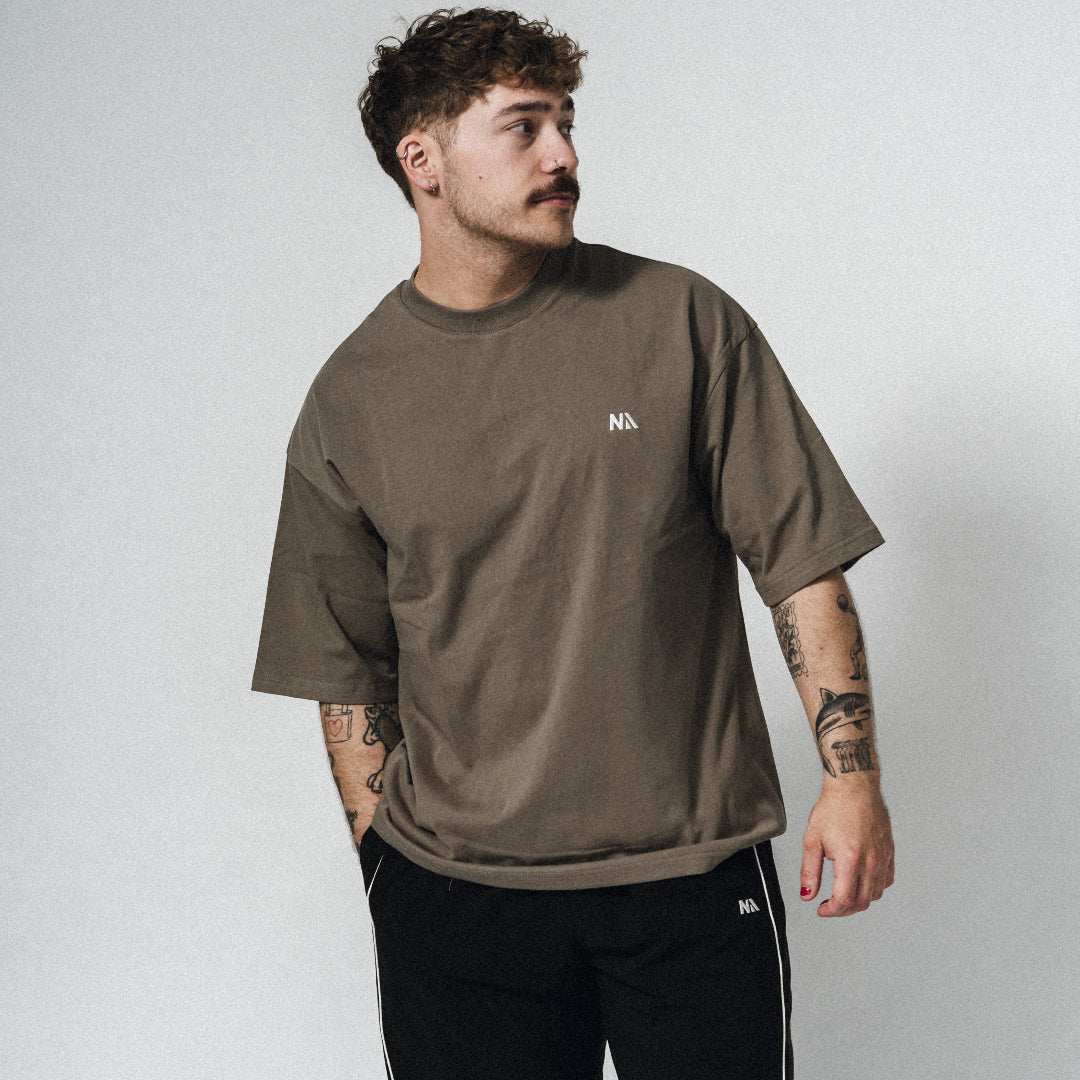 NA's Oversized t-shirt er beskrevet som det perfekte pump cover, gennemført pasform og maksimal komfort. Det bløde og åndbare bomuld kombineret med det ikoniske oversized box fit - gør den ideel som både træningstrøje og casual hverdagslook. Med drop shoulders og et naturligt fald over brystet, der skaber en flatterende silhuet, går du aldrig galt i byen med den her t-shirt.