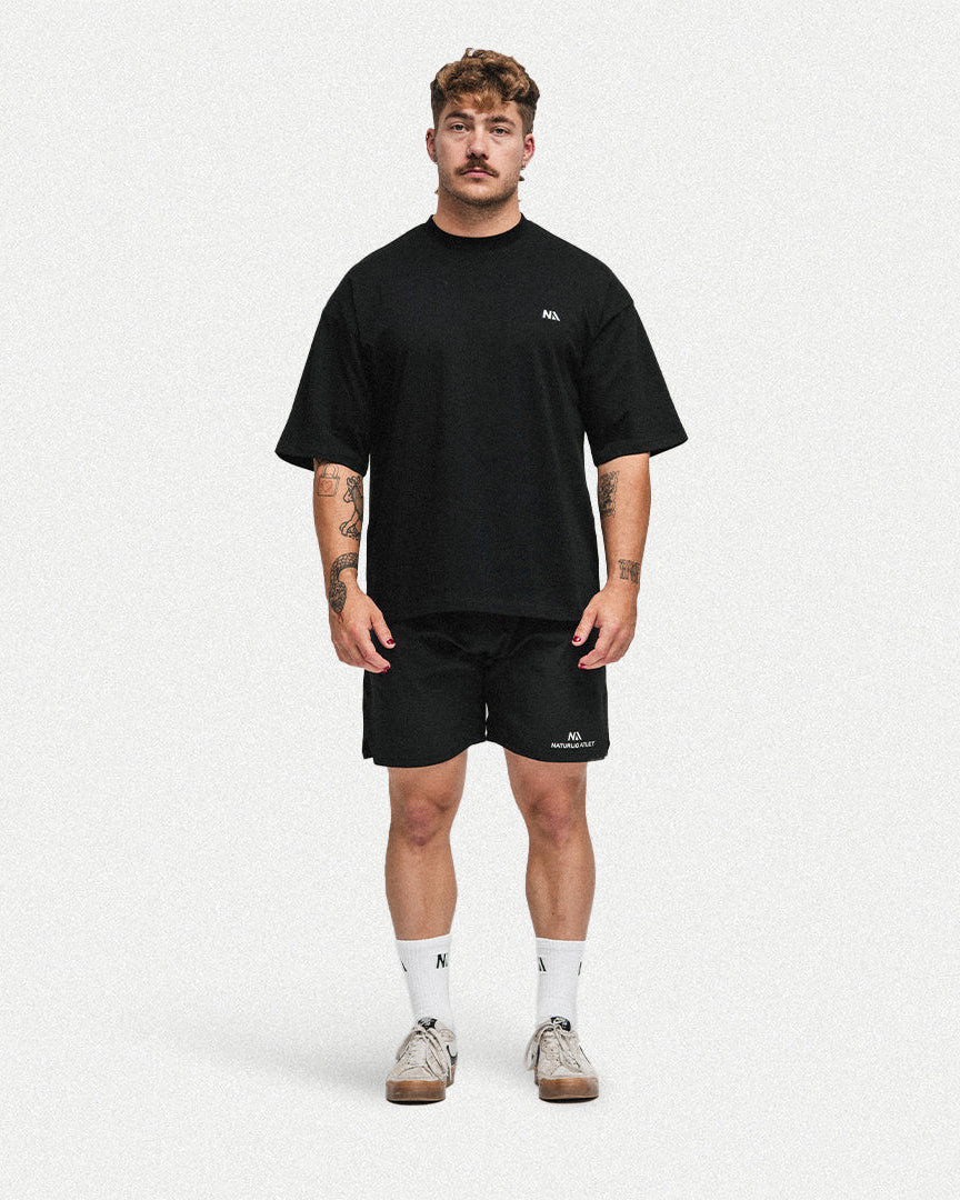 Naturlig Atlets Oversized T-shirt er intet mindre end det perfekte pump cover. Designet i et gennemført box fit med drop shoulders i 100% 240gsm tætvævet bomuld, som gør den både behagelig og utrolig blød at træne i.